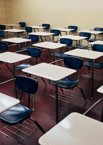 Σχολική τσάντα και βιβλία πάνω σε θρανίο σε άδεια σχολική αίθουσα